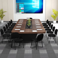 The office chairs arranged in rows around a long boardroom table with a large screen behind