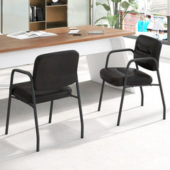 The office chairs placed in a modern workspace next to a wooden desk with a laptop and stationery