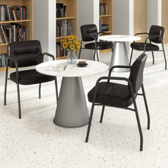 The office chairs arranged around small round tables in a bright and open professional waiting area