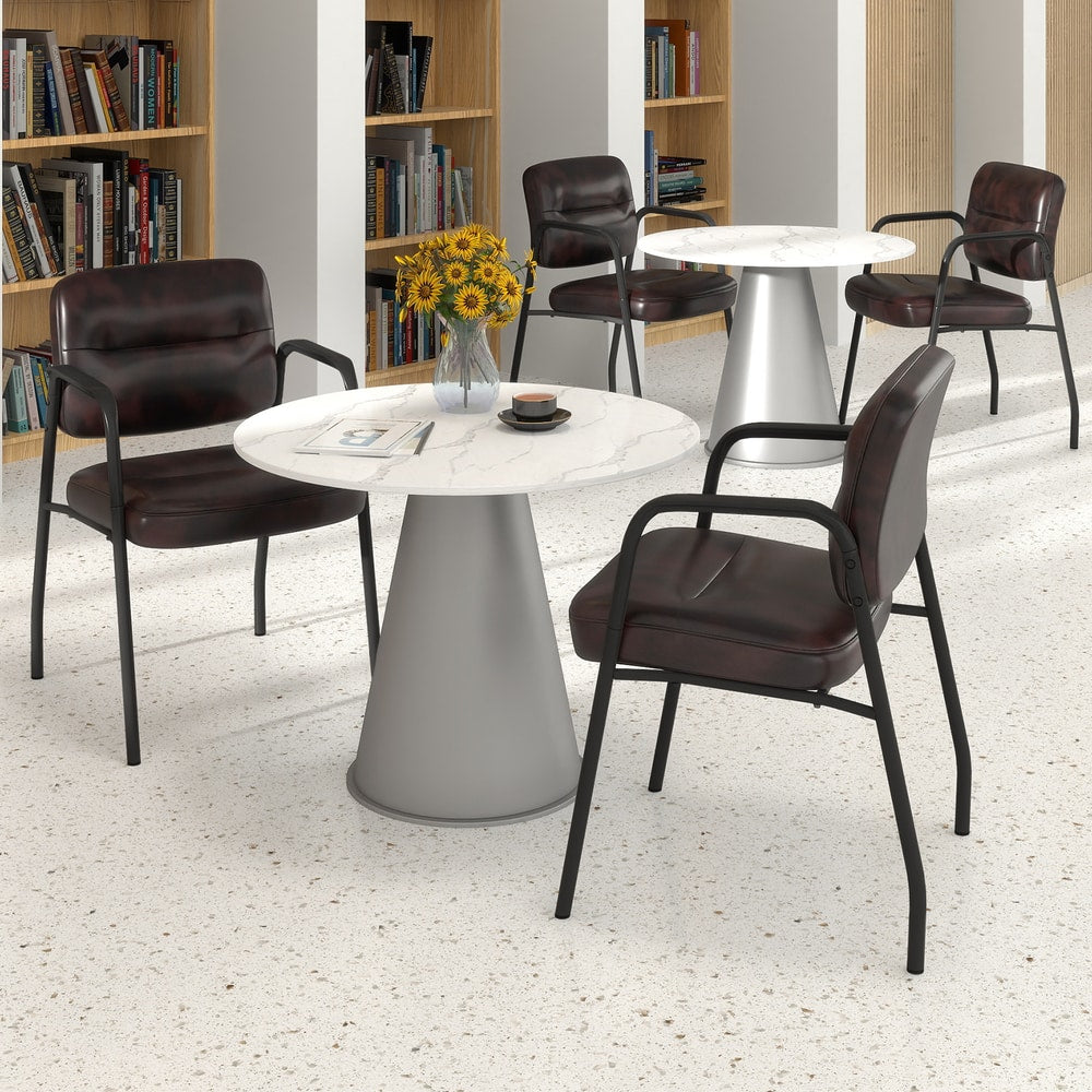 Four rustic brown waiting room chairs arranged around a table in a modern office