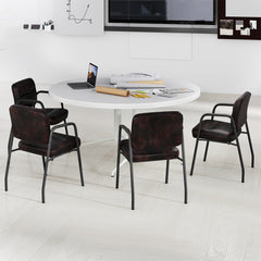 Four rustic brown waiting room chairs around a circular table in a meeting room