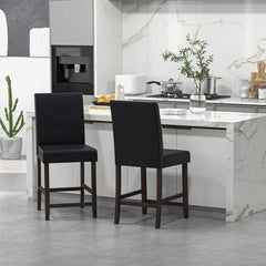 The bar stools positioned near a kitchen counter with a marble top and white cabinetry