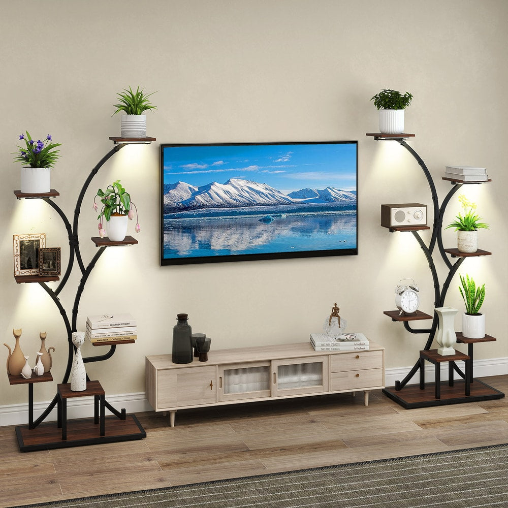 Two brown metal plant stands with plants in a living room with a TV