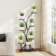 A brown metal plant stand with plants next to a sofa and window