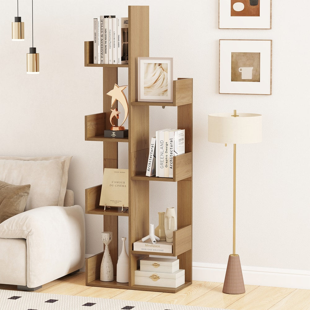 A natural wood tree-shaped bookcase filled with books and decorative items in a living room