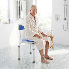Elderly man sitting on the shower chair in a bathroom