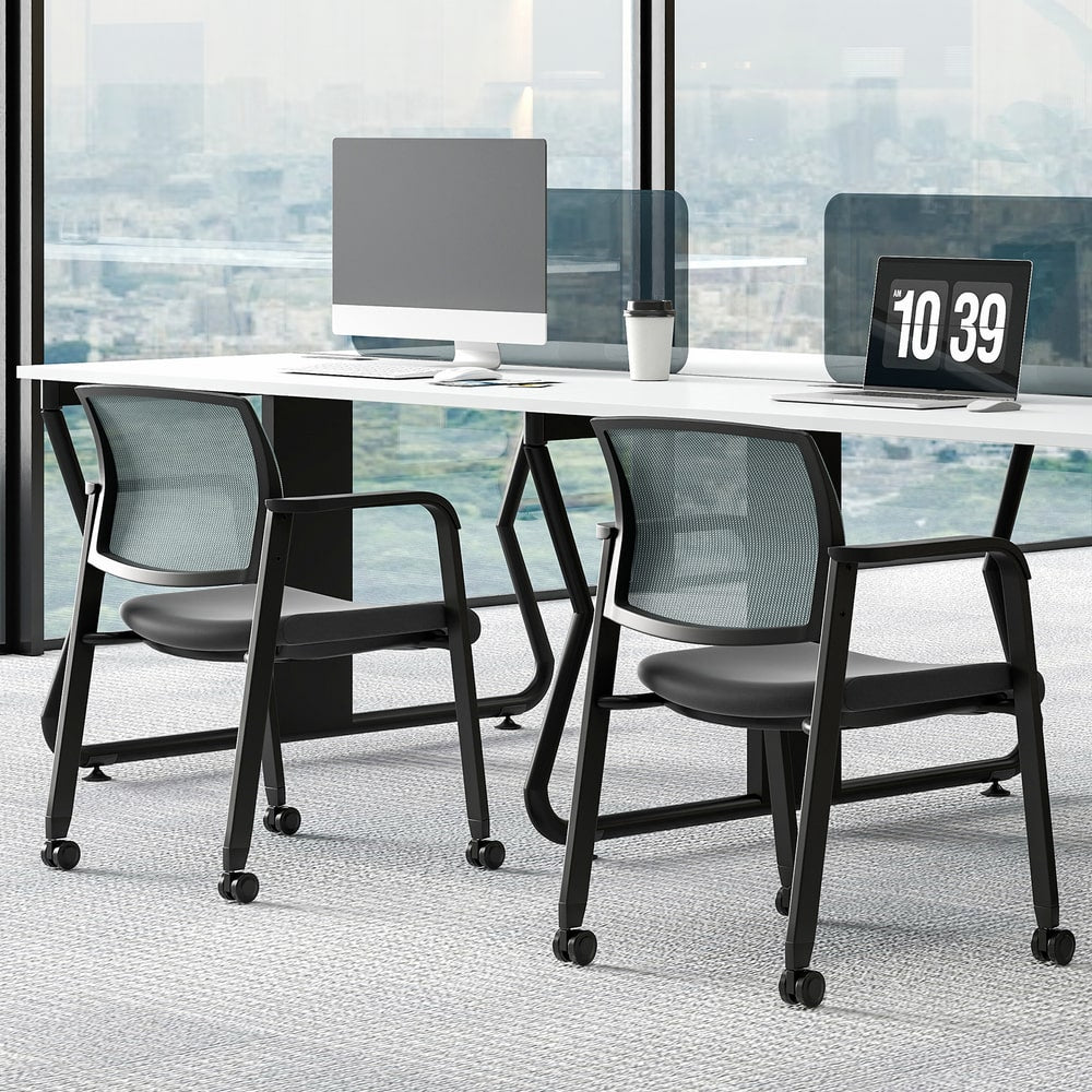 Two grey office chairs with wheels placed next to a desk in a contemporary office