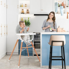 The wooden baby infant high chair in use in a modern kitchen with a mother and baby