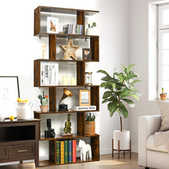 The wooden bookcase placed beside a large potted plant and a small side table