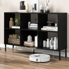 The black open bookshelf with a robot vacuum cleaner underneath