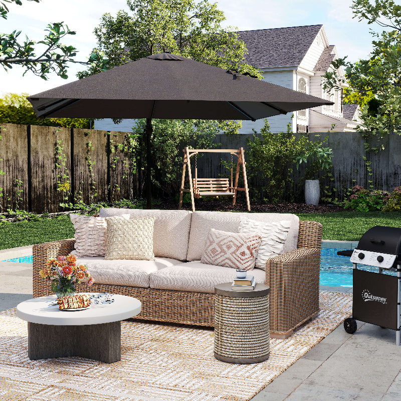 Outdoor patio set with sofa, table, and umbrella on a patio with pool and backyard.