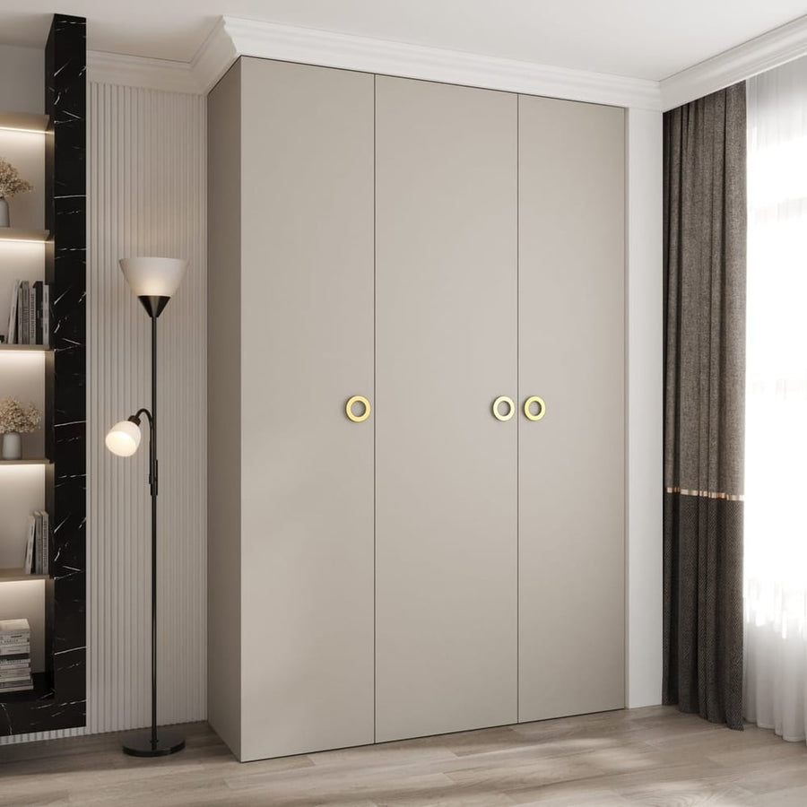 Como I Hinged Door Wardrobe 160cm in a light grey finish with gold circular handles in a bedroom
