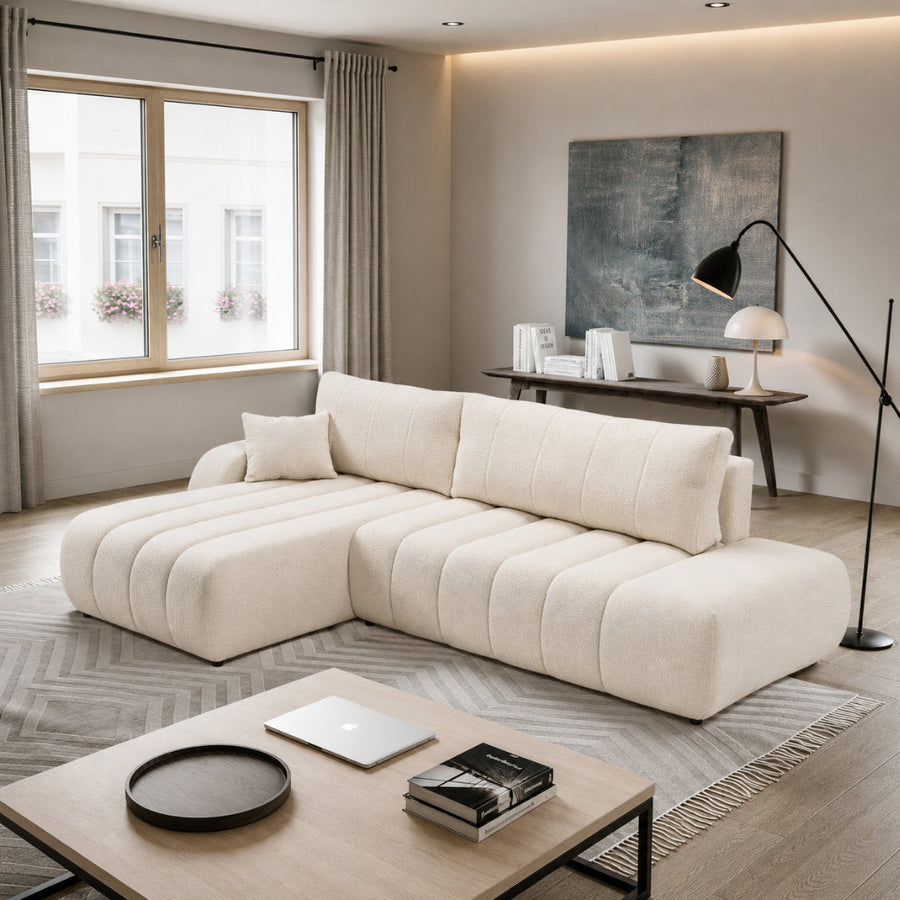 Corner Sofa Bed Baloo in a light cream fabric shown in a bright modern living room setting