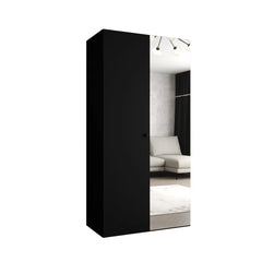 The hinged wardrobe finished in a solid matte black with a vertical mirror door