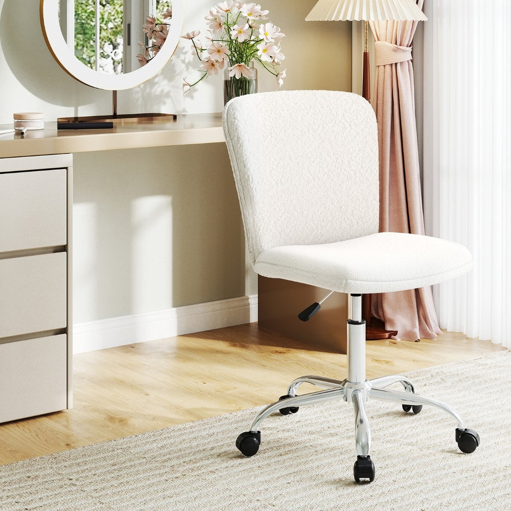 White ergonomic office chair with wheels in a bright room setting next to a dressing table