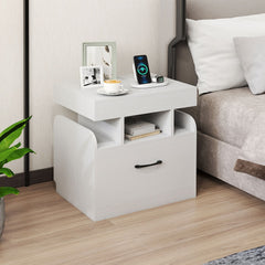 White bedside table with drawer and open shelf next to a bed
