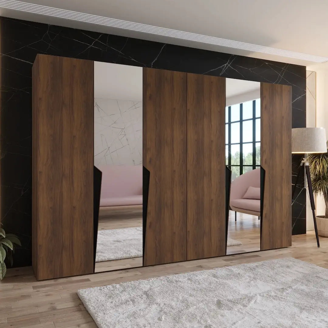 The hinged wardrobe in a dark wood finish with mirrors in a furnished room