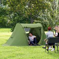 The camping tent set up in a grassy garden with two people sitting outside